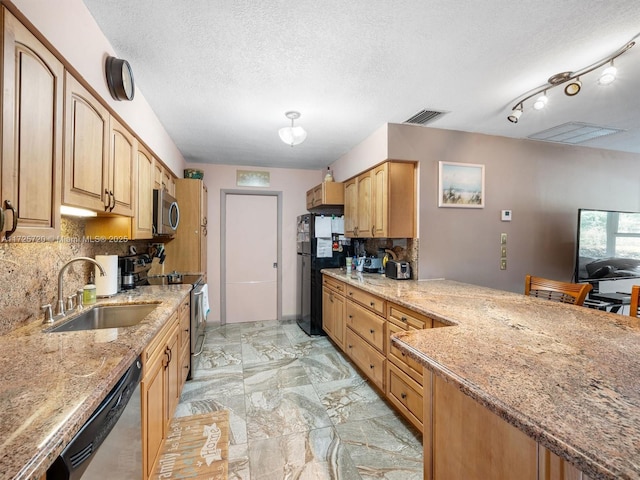 kitchen with decorative backsplash, appliances with stainless steel finishes, sink, and light stone counters