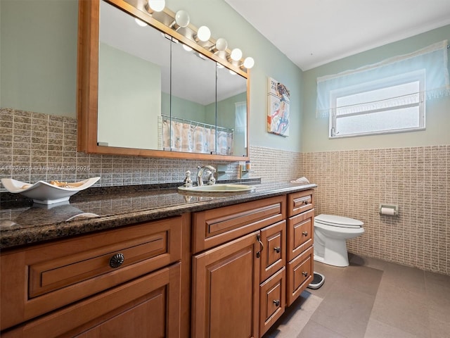 bathroom with tile walls, tile patterned floors, vanity, and toilet