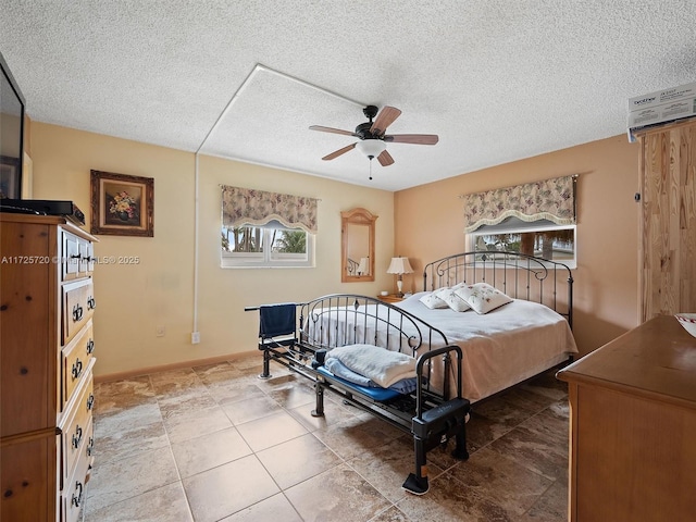 bedroom with ceiling fan, a textured ceiling, and an AC wall unit