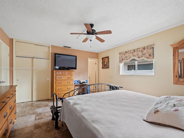 bedroom with ceiling fan, a closet, and a textured ceiling