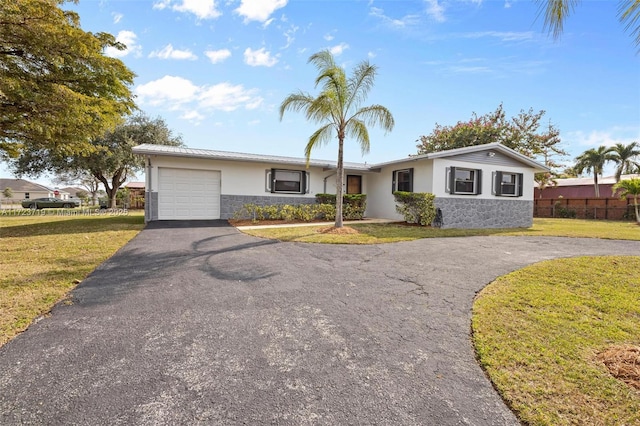 ranch-style home featuring a front lawn and a garage