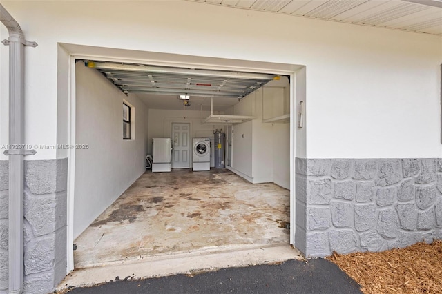 garage with independent washer and dryer and a garage door opener