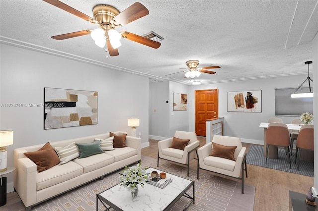 living room featuring ceiling fan, wood-type flooring, and a textured ceiling