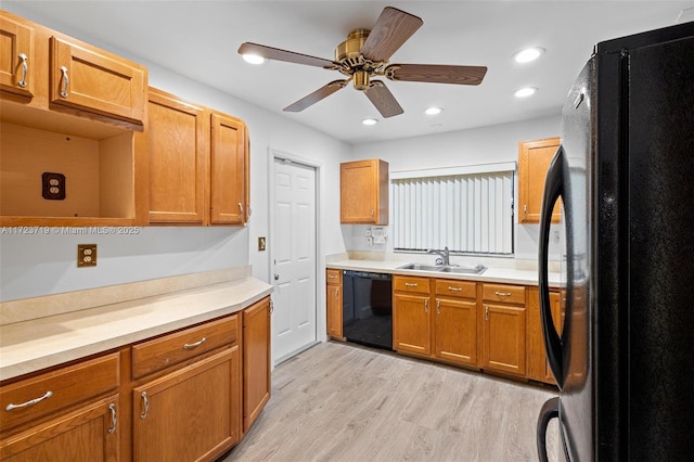 kitchen with black appliances, ceiling fan, sink, and light hardwood / wood-style flooring