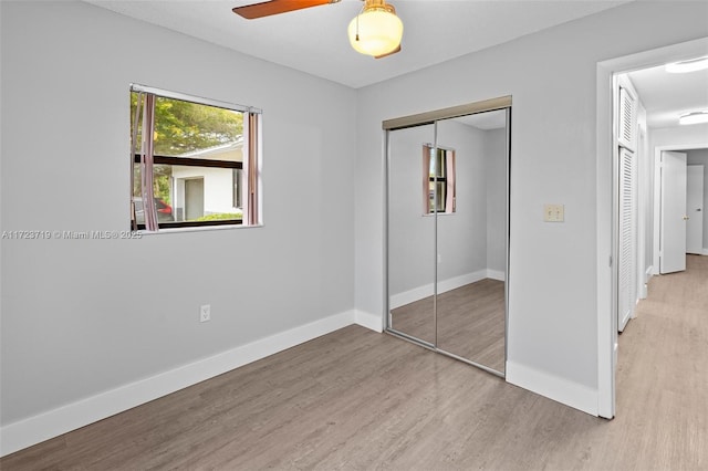 unfurnished bedroom featuring ceiling fan, a closet, and light hardwood / wood-style flooring