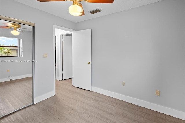 unfurnished bedroom featuring ceiling fan, a closet, and light hardwood / wood-style floors