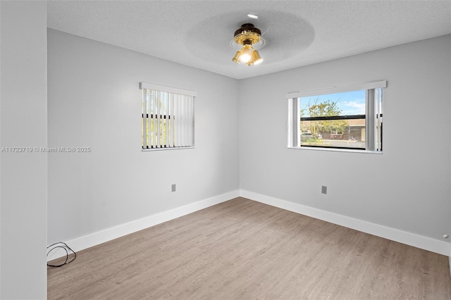 unfurnished room with ceiling fan, wood-type flooring, and a textured ceiling