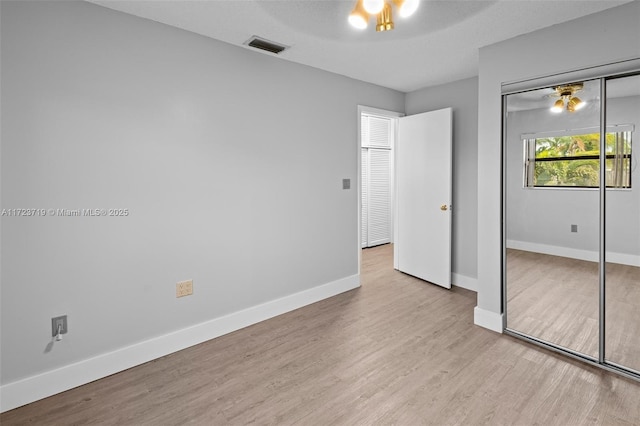 unfurnished bedroom with a closet and light hardwood / wood-style flooring