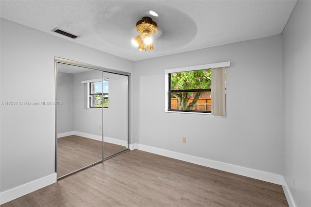 unfurnished bedroom featuring a textured ceiling, ceiling fan, and a closet