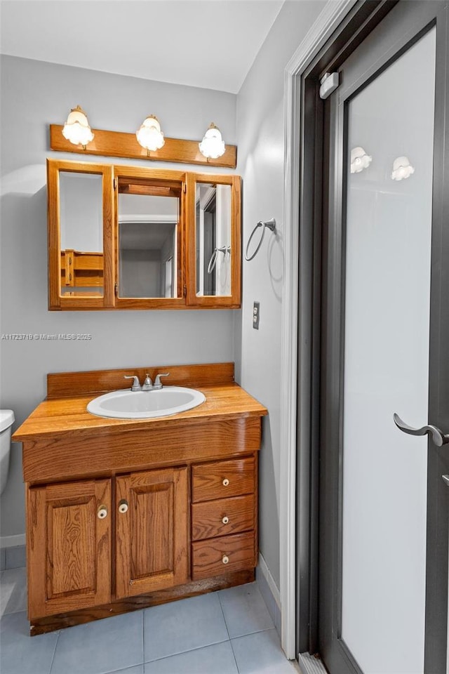 bathroom featuring toilet, vanity, and tile patterned flooring