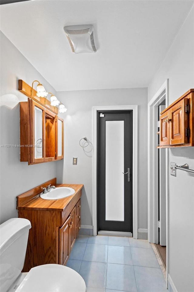 bathroom featuring toilet, tile patterned flooring, and vanity