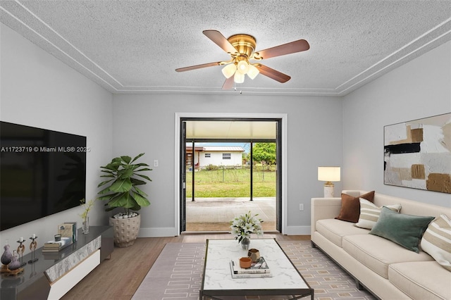 living room featuring a textured ceiling, ceiling fan, and wood-type flooring