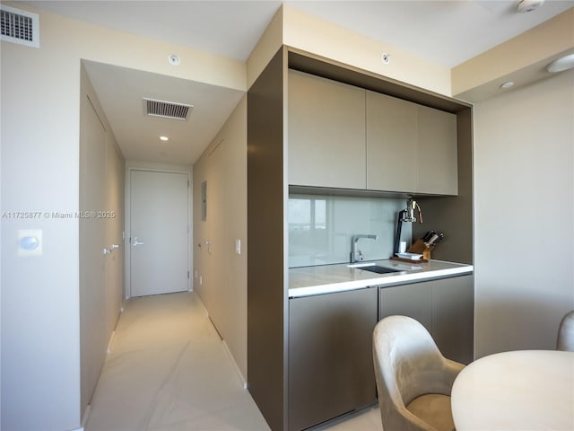 kitchen featuring gray cabinets, tasteful backsplash, and sink