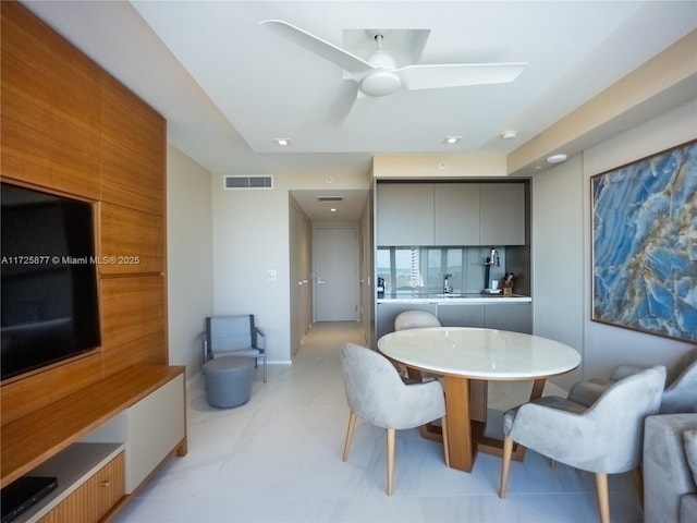 dining area with ceiling fan and sink