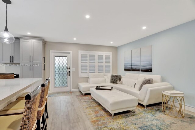 kitchen featuring kitchen peninsula, pendant lighting, a breakfast bar area, white cabinets, and appliances with stainless steel finishes