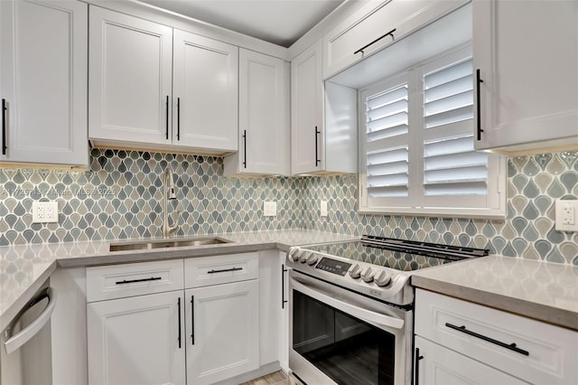 kitchen with appliances with stainless steel finishes, tasteful backsplash, white cabinetry, and sink