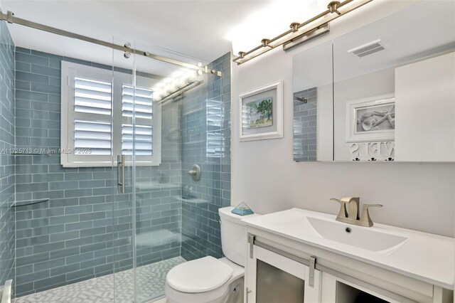 bathroom featuring toilet, vanity, and walk in shower