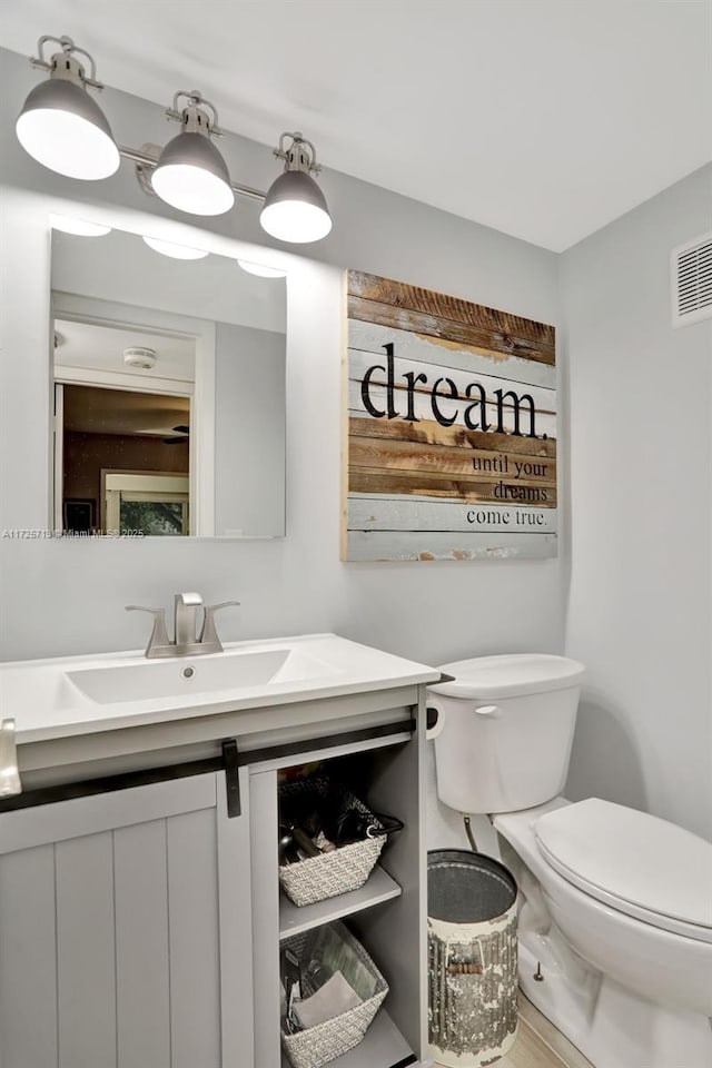 bathroom featuring toilet and vanity