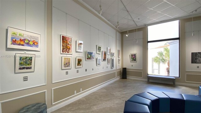 interior space with a towering ceiling and crown molding