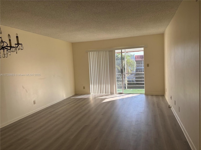 empty room featuring a textured ceiling and dark hardwood / wood-style flooring