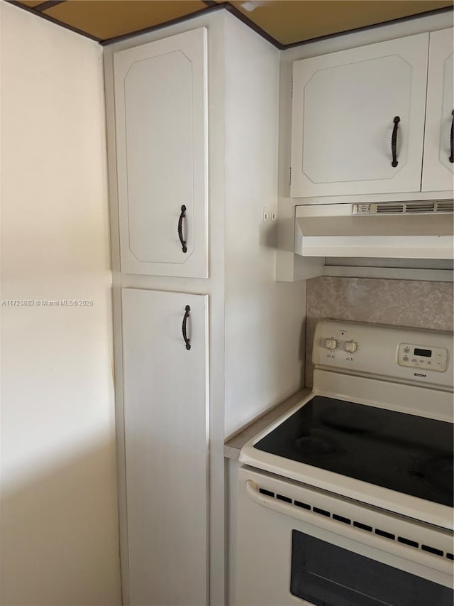 kitchen featuring white cabinets and electric range