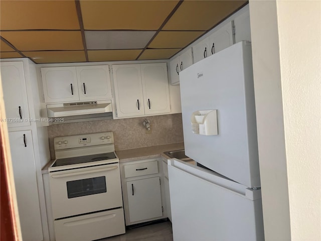 kitchen featuring white appliances, white cabinetry, tasteful backsplash, and a drop ceiling