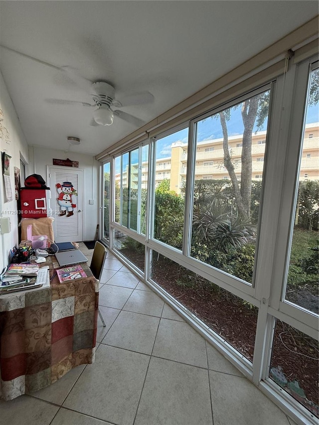 unfurnished sunroom featuring ceiling fan and a wealth of natural light