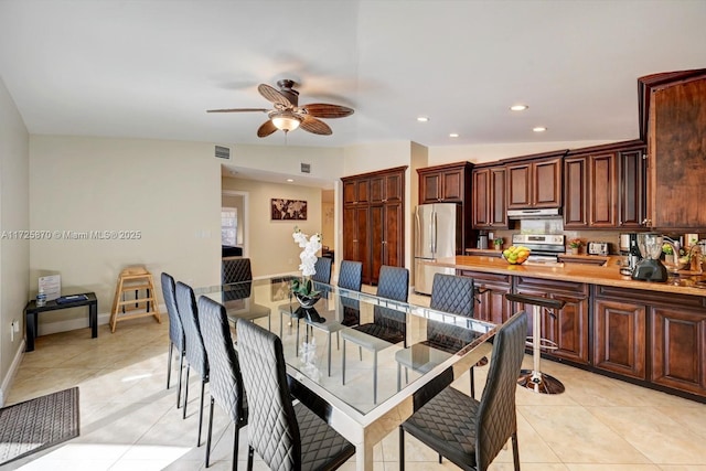 tiled dining area with lofted ceiling and ceiling fan