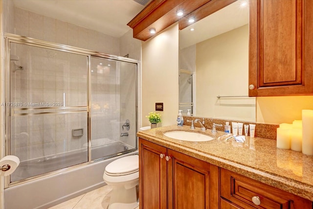 full bathroom with vanity, toilet, combined bath / shower with glass door, and tile patterned floors