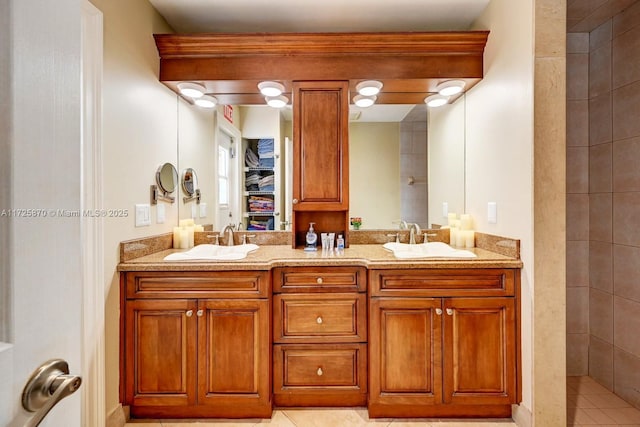 bathroom featuring a tile shower, vanity, and tile patterned floors