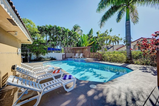 view of swimming pool featuring a patio area and an in ground hot tub