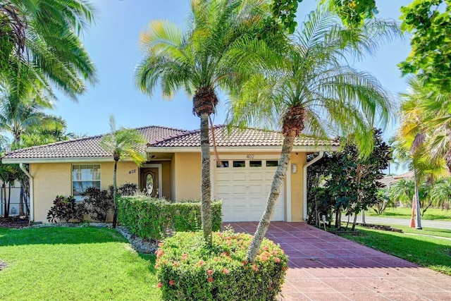 mediterranean / spanish-style home featuring a front yard and a garage