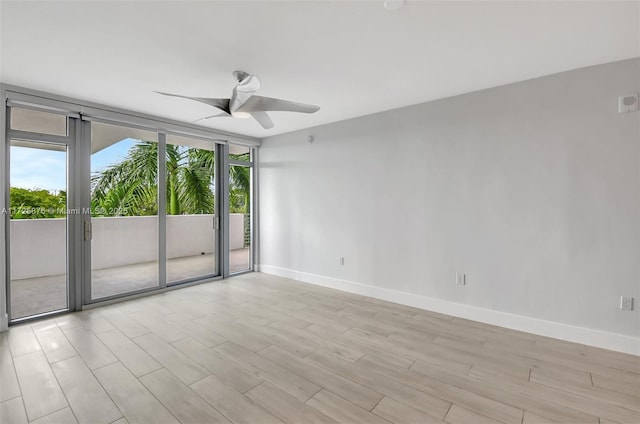 empty room featuring ceiling fan and expansive windows