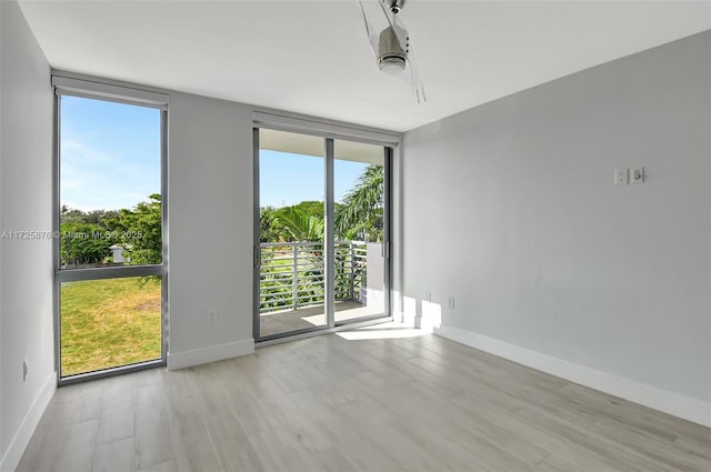 unfurnished room featuring light wood-type flooring and floor to ceiling windows