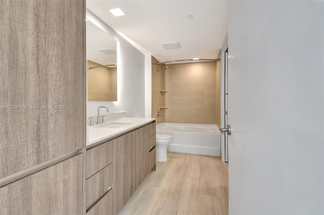 full bathroom featuring toilet, washtub / shower combination, wood-type flooring, and vanity