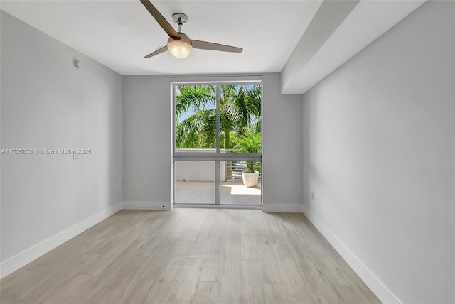 spare room featuring floor to ceiling windows, ceiling fan, and light hardwood / wood-style floors