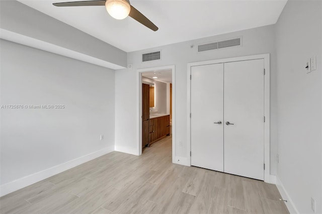 unfurnished bedroom with ensuite bath, ceiling fan, light hardwood / wood-style floors, and a closet