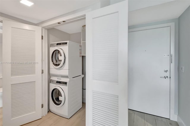 washroom featuring stacked washing maching and dryer and light hardwood / wood-style floors