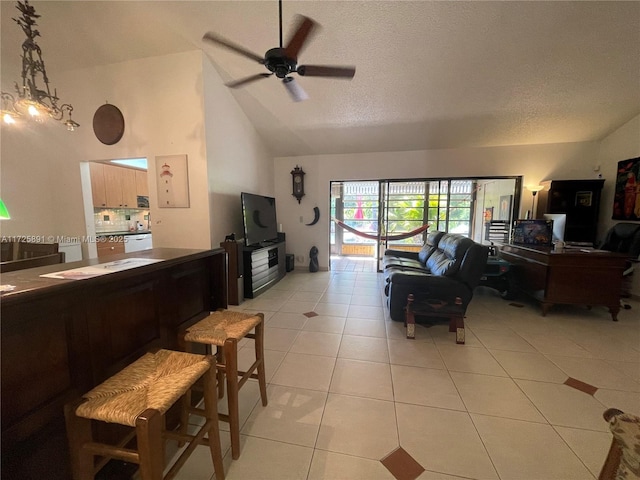 living room with light tile patterned floors, a textured ceiling, ceiling fan, and vaulted ceiling