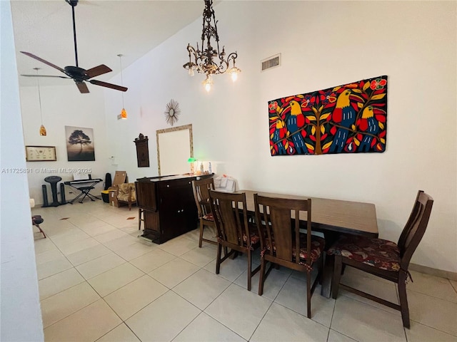 tiled dining space featuring ceiling fan with notable chandelier and high vaulted ceiling