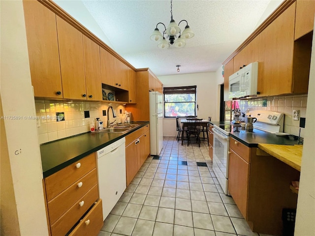 kitchen with white appliances, light tile patterned floors, a notable chandelier, a textured ceiling, and sink