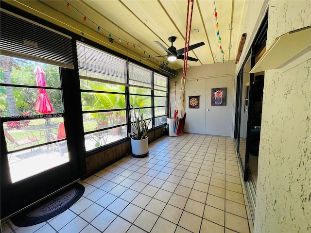 unfurnished sunroom with ceiling fan and a healthy amount of sunlight