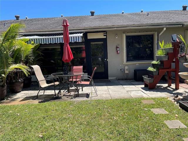 back of property featuring a yard and a patio area