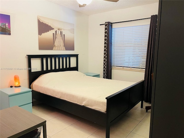 bedroom featuring light tile patterned flooring, a textured ceiling, and ceiling fan