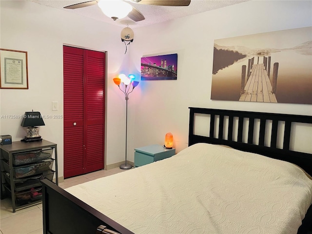 tiled bedroom featuring a closet, ceiling fan, and a textured ceiling