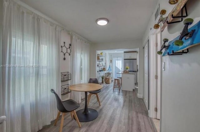 hallway with light hardwood / wood-style floors and plenty of natural light