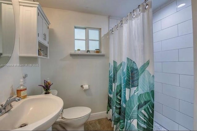 bathroom featuring toilet, a shower with curtain, and sink