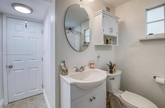 bathroom with toilet, vanity, and a shower with curtain