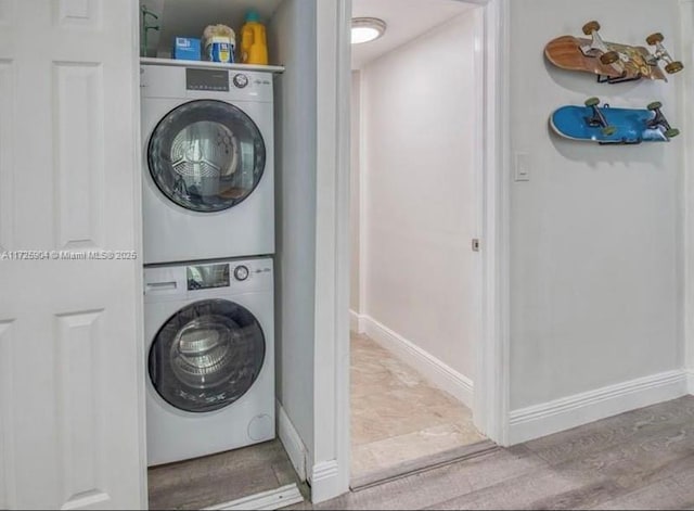 laundry room featuring stacked washer / dryer and light wood-type flooring