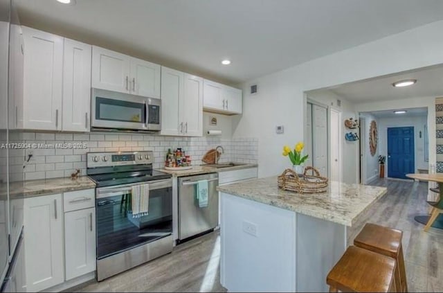 kitchen with sink, stainless steel appliances, and white cabinetry